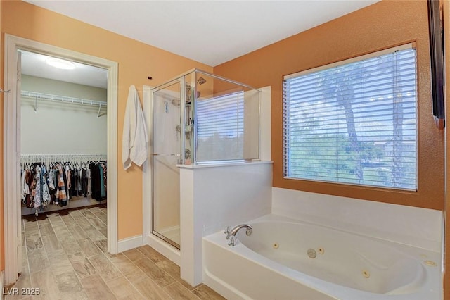 6409 Sea Swallow St, North Las Vegas, NV 89084 - bathroom featuring a shower stall, a tub with jets, a walk in closet, and wood finished floors