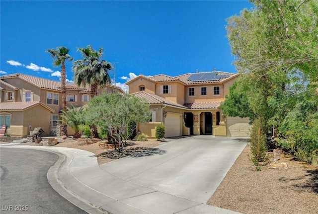 6409 Sea Swallow St, North Las Vegas, NV 89084 - mediterranean / spanish home featuring a tiled roof, concrete driveway, stucco siding, roof mounted solar panels, and a garage