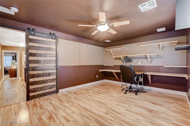 6409 Sea Swallow St, North Las Vegas, NV 89084 - office with wood finished floors, ceiling fan, baseboards, and a barn door
