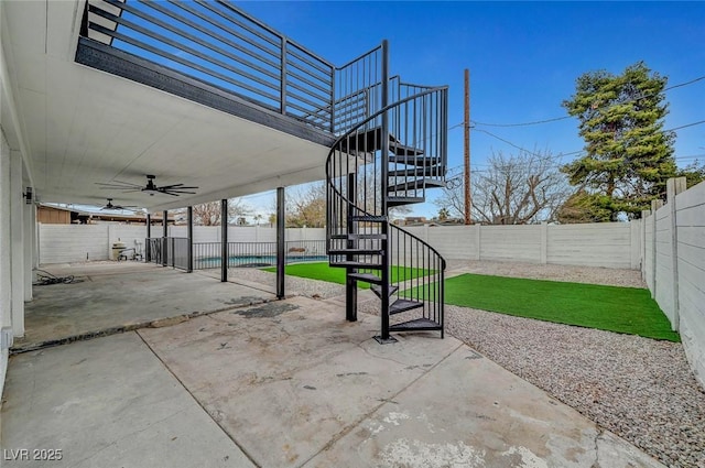view of patio featuring stairway, a fenced backyard, and ceiling fan