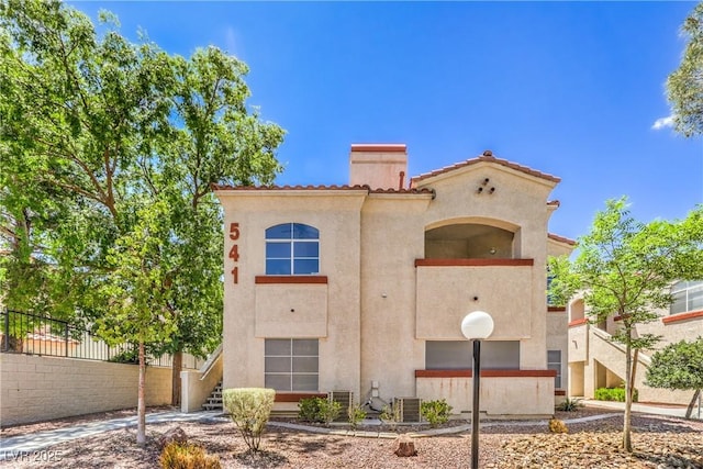 541 Indian Bluff St Unit 201, Las Vegas, NV 89145 - view of front of house featuring stucco siding, a tiled roof, fence, and a chimney