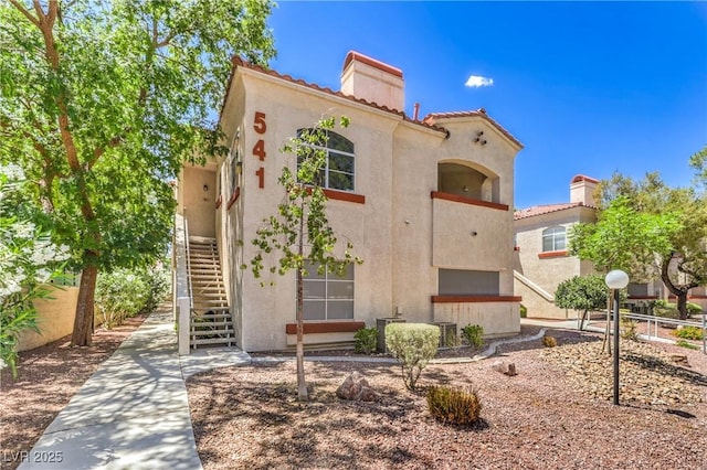 541 Indian Bluff St Unit 201, Las Vegas, NV 89145 - view of front of home with stairway, stucco siding, a chimney, and a tiled roof