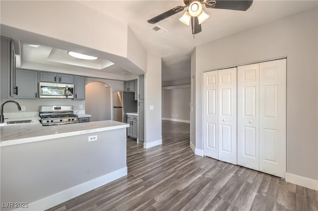 541 Indian Bluff St Unit 201, Las Vegas, NV 89145 - kitchen featuring appliances with stainless steel finishes, arched walkways, gray cabinetry, a sink, and a ceiling fan