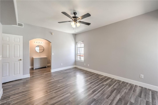 541 Indian Bluff St Unit 201, Las Vegas, NV 89145 - empty room with arched walkways, ceiling fan, dark wood-style floors, and baseboards