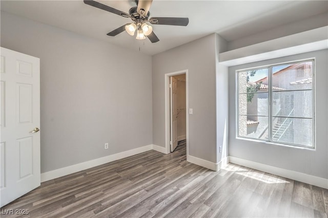541 Indian Bluff St Unit 201, Las Vegas, NV 89145 - unfurnished bedroom with wood finished floors, baseboards, a ceiling fan, and a walk in closet