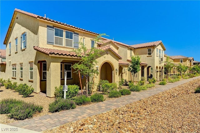 mediterranean / spanish-style house with a tiled roof and stucco siding
