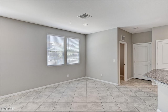 empty room with light tile patterned flooring and baseboards
