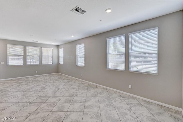 empty room with light tile patterned floors, baseboards, and recessed lighting