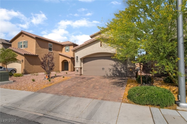 162 Sand Lake St, Henderson, NV 89074 - mediterranean / spanish home featuring decorative driveway, stucco siding, a tiled roof, and a garage