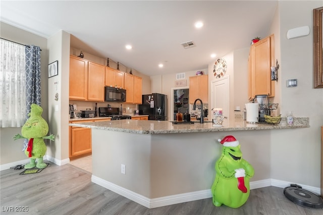 162 Sand Lake St, Henderson, NV 89074 - kitchen featuring black appliances, a peninsula, light wood-style flooring, a sink, and recessed lighting