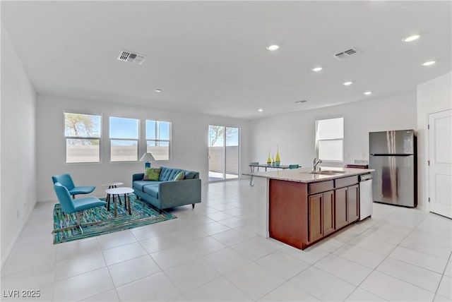 7256 Saxby Ave, Las Vegas, NV 89113 - kitchen with stainless steel appliances, a sink, open floor plan, recessed lighting, and an island with sink