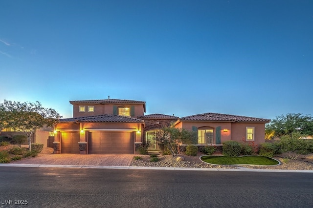 9760 Arch Canyon Ct, Las Vegas, NV 89149 - mediterranean / spanish house featuring an attached garage, a tiled roof, driveway, and stucco siding
