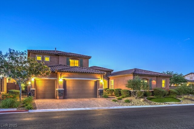 9760 Arch Canyon Ct, Las Vegas, NV 89149 - mediterranean / spanish-style home with driveway, stucco siding, a tiled roof, and a garage