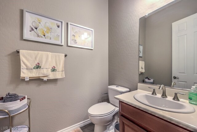 9760 Arch Canyon Ct, Las Vegas, NV 89149 - bathroom with toilet, vanity, wood finished floors, baseboards, and a textured wall