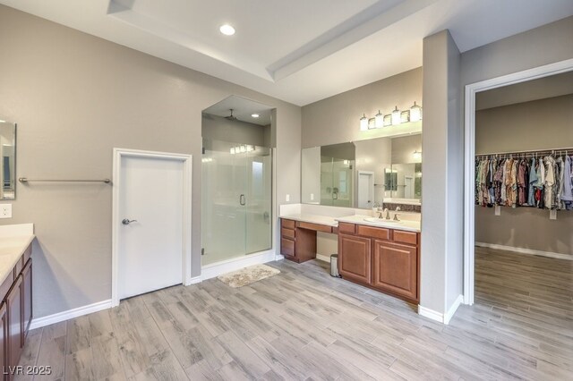 9760 Arch Canyon Ct, Las Vegas, NV 89149 - full bathroom featuring a shower stall, wood finished floors, two vanities, baseboards, and recessed lighting