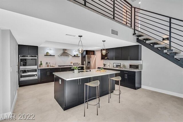 778 Vegas Valley Dr, Las Vegas, NV 89109 - kitchen with wall chimney exhaust hood, stainless steel appliances, baseboards, light countertops, and a towering ceiling
