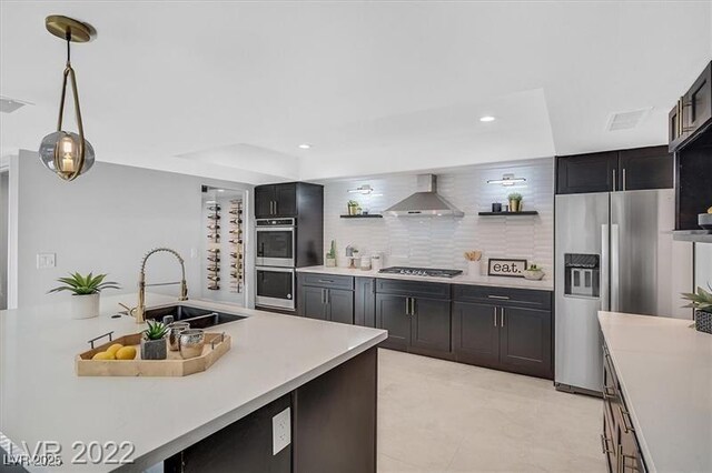 778 Vegas Valley Dr, Las Vegas, NV 89109 - kitchen featuring appliances with stainless steel finishes, wall chimney range hood, a sink, light countertops, and dark cabinets