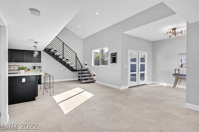 778 Vegas Valley Dr, Las Vegas, NV 89109 - living area with stairway, baseboards, a chandelier, and vaulted ceiling