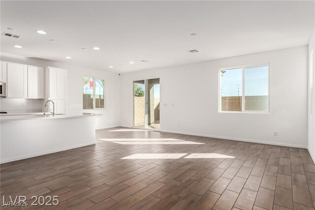 10328 Apefly St, Las Vegas, NV 89141 - unfurnished living room featuring recessed lighting, wood finished floors, a sink, and baseboards