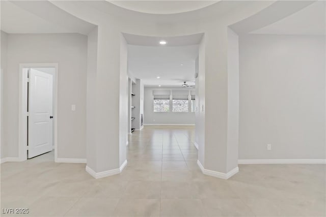 corridor featuring recessed lighting, baseboards, and light tile patterned flooring