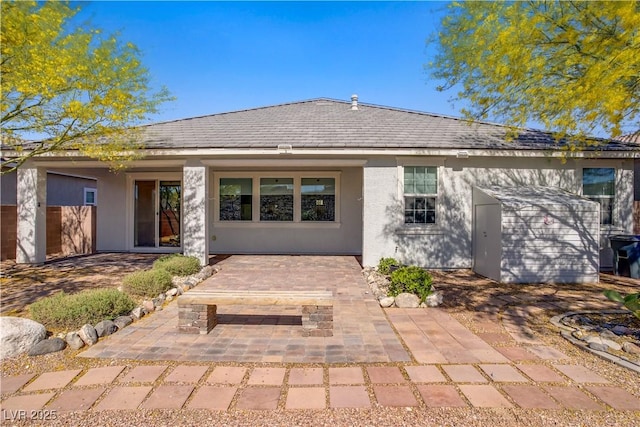 rear view of house with a patio area and stucco siding