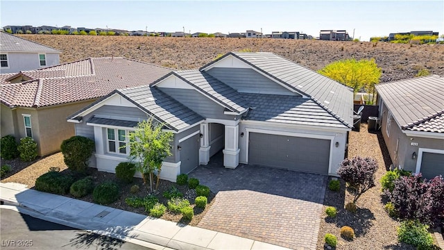 view of front facade with an attached garage, decorative driveway, a residential view, and stucco siding