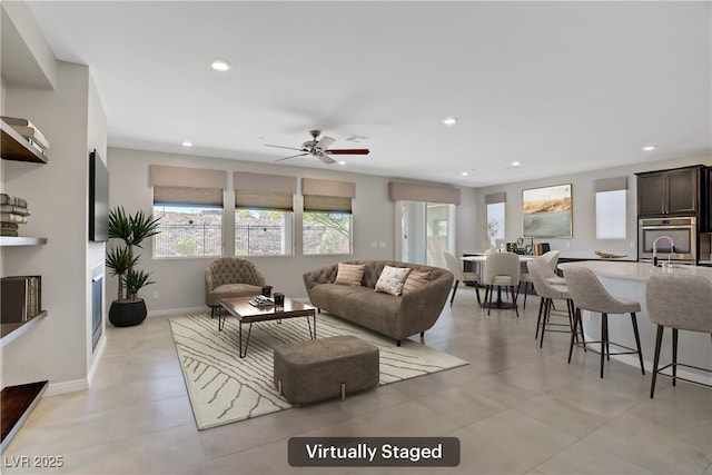 living area featuring recessed lighting, ceiling fan, and baseboards