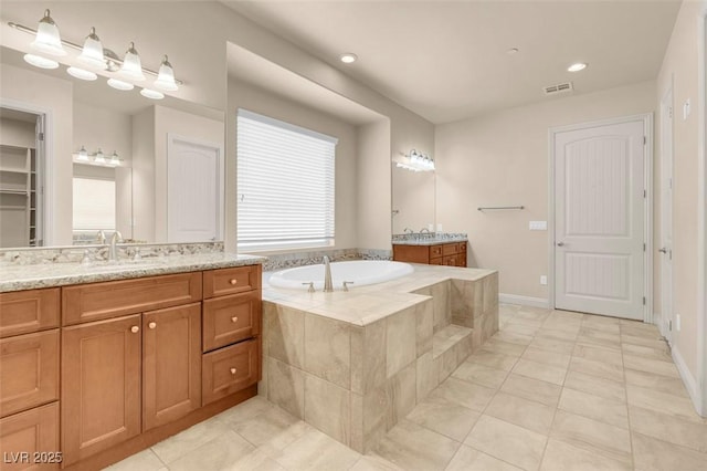 7668 Friendly Breeze Ct, Las Vegas, NV 89123 - full bathroom with tile patterned floors, two vanities, a garden tub, plenty of natural light, and recessed lighting