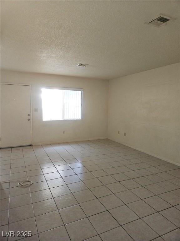 1128 Willow Tree Dr Unit C, Las Vegas, NV 89128 - spare room featuring light tile patterned floors and a textured ceiling