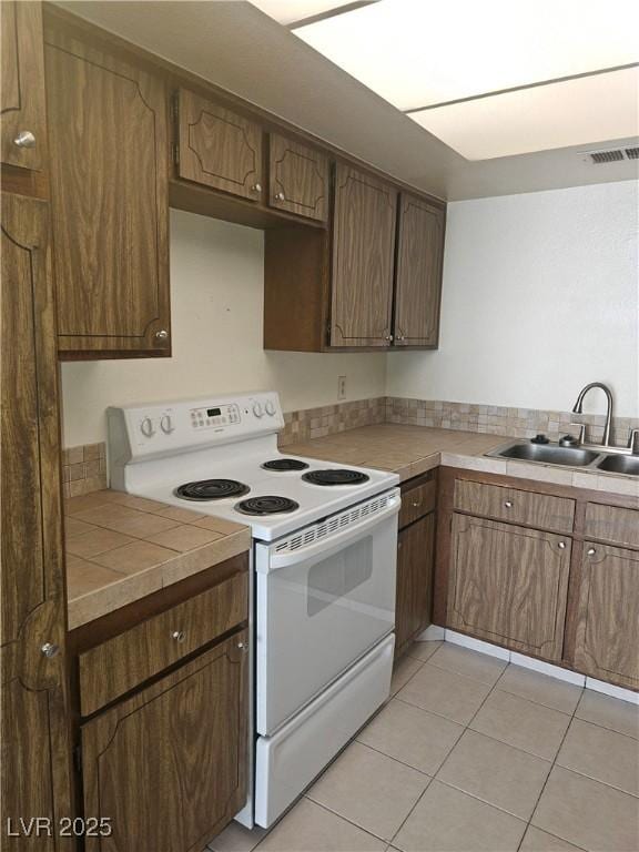 1128 Willow Tree Dr Unit C, Las Vegas, NV 89128 - kitchen featuring electric stove, light tile patterned flooring, and tile counters