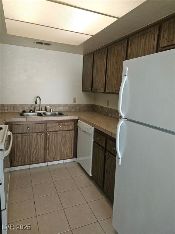 1128 Willow Tree Dr Unit C, Las Vegas, NV 89128 - kitchen featuring white appliances, light tile patterned floors, and tile counters