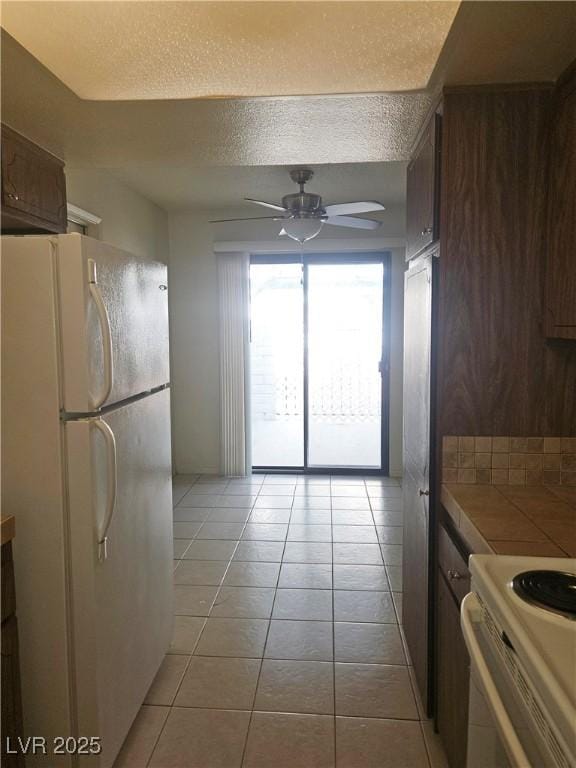1128 Willow Tree Dr Unit C, Las Vegas, NV 89128 - kitchen with white appliances, tile countertops, a ceiling fan, light tile patterned floors, and a textured ceiling