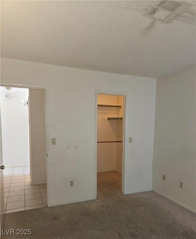 1128 Willow Tree Dr Unit C, Las Vegas, NV 89128 - unfurnished bedroom featuring a spacious closet, a textured ceiling, and light colored carpet