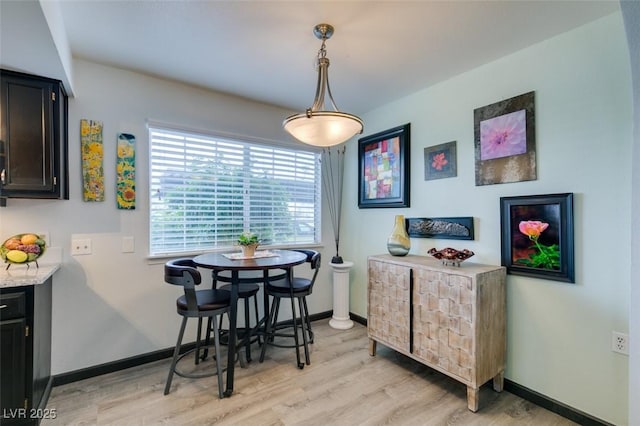 dining area with light wood-style flooring and baseboards
