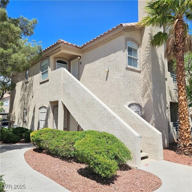 5415 W Harmon Ave Unit 2094, Las Vegas, NV 89103 - view of home's exterior featuring stucco siding and a tiled roof