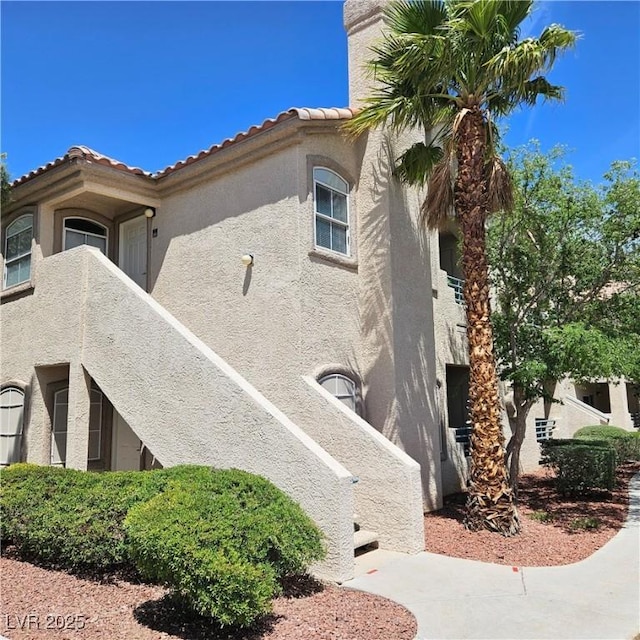 5415 W Harmon Ave Unit 2094, Las Vegas, NV 89103 - view of side of home featuring stucco siding and a tiled roof
