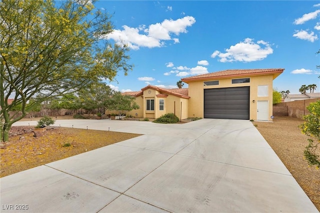 4185 W Arby Ave, Las Vegas, NV 89118 - mediterranean / spanish-style home with a tile roof, concrete driveway, stucco siding, an attached garage, and fence