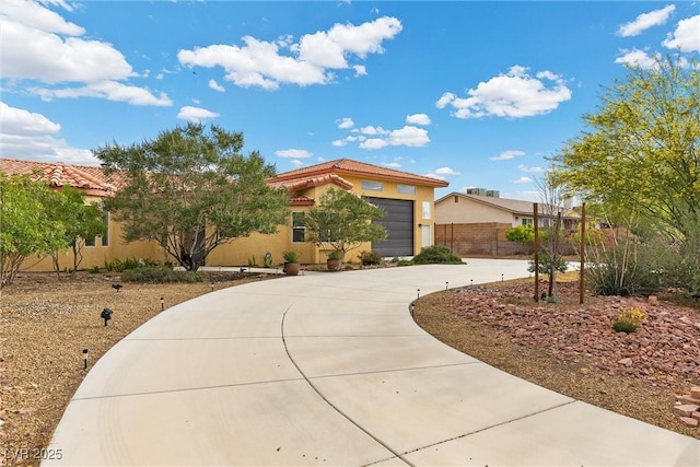 4185 W Arby Ave, Las Vegas, NV 89118 - view of front facade featuring stucco siding, curved driveway, a tile roof, fence, and a garage