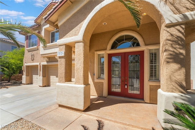 395 Suzanne Peak Ct, Henderson, NV 89012 - entrance to property featuring french doors, an attached garage, concrete driveway, and stucco siding