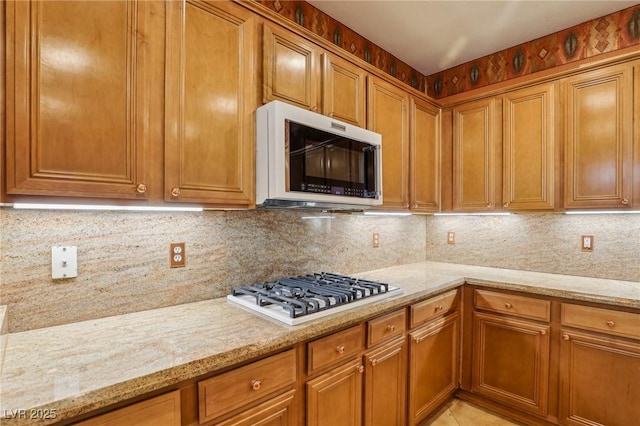 395 Suzanne Peak Ct, Henderson, NV 89012 - kitchen with stainless steel microwave, gas stovetop, and backsplash