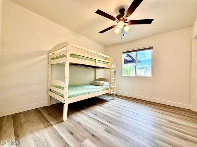 4881 E Imperial Ave, Las Vegas, NV 89104 - unfurnished bedroom with baseboards, wood finished floors, and a ceiling fan