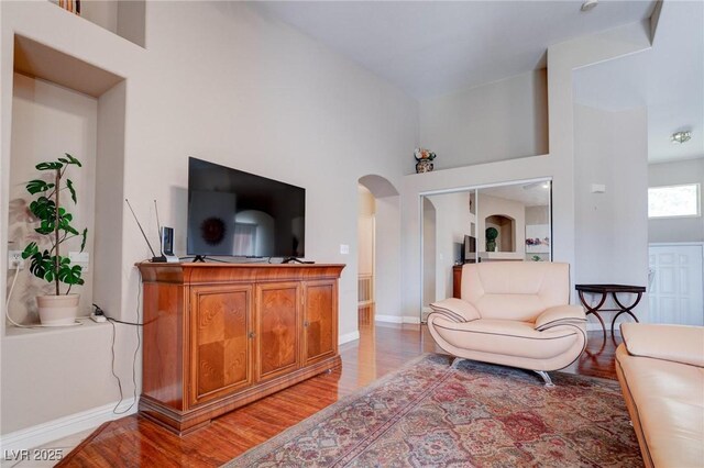 5000 Red Rock St Unit 237, Las Vegas, NV 89118 - living room featuring light wood finished floors, arched walkways, baseboards, and a high ceiling