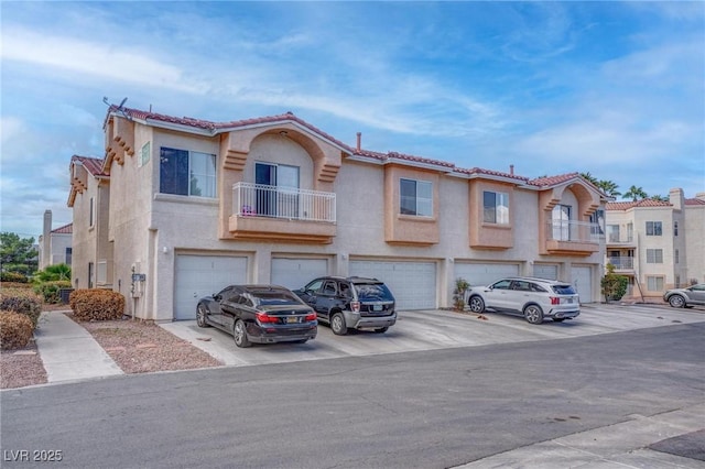 5000 Red Rock St Unit 237, Las Vegas, NV 89118 - townhome / multi-family property featuring a garage, driveway, a tile roof, stucco siding, and a balcony