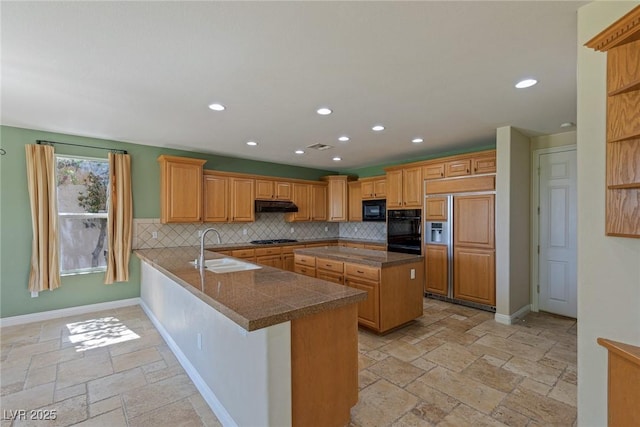 10761 Capesthorne Way, Las Vegas, NV 89135 - kitchen featuring a sink, under cabinet range hood, black appliances, stone tile flooring, and a peninsula