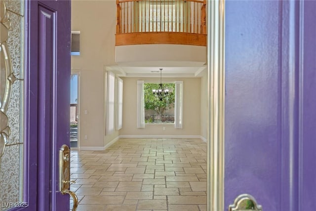 10761 Capesthorne Way, Las Vegas, NV 89135 - foyer entrance featuring a chandelier, baseboards, and stone tile flooring