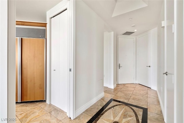 hall with baseboards, inlaid floor details, a skylight, and recessed lighting