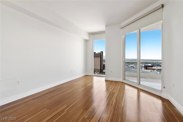 spare room with wood finished floors and baseboards