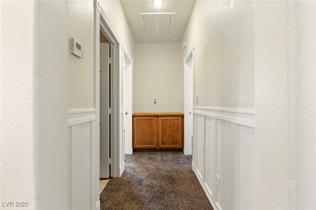 5380 Flowing Spring St, Las Vegas, NV 89122 - corridor featuring dark carpet, attic access, and a wainscoted wall
