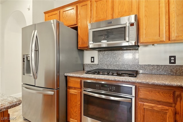 5380 Flowing Spring St, Las Vegas, NV 89122 - kitchen featuring stainless steel appliances, backsplash, brown cabinets, and light countertops