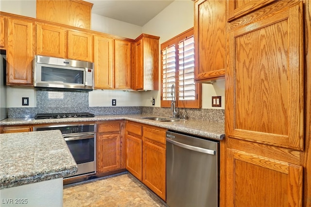 5380 Flowing Spring St, Las Vegas, NV 89122 - kitchen featuring stainless steel appliances, backsplash, brown cabinets, and light countertops